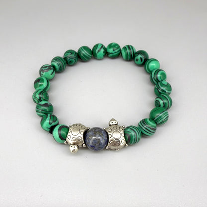 Malachite beaded bracelet, 18cm, green gemstone beads with central blue bead framed by two metal turtle accents on elastic stretch band.