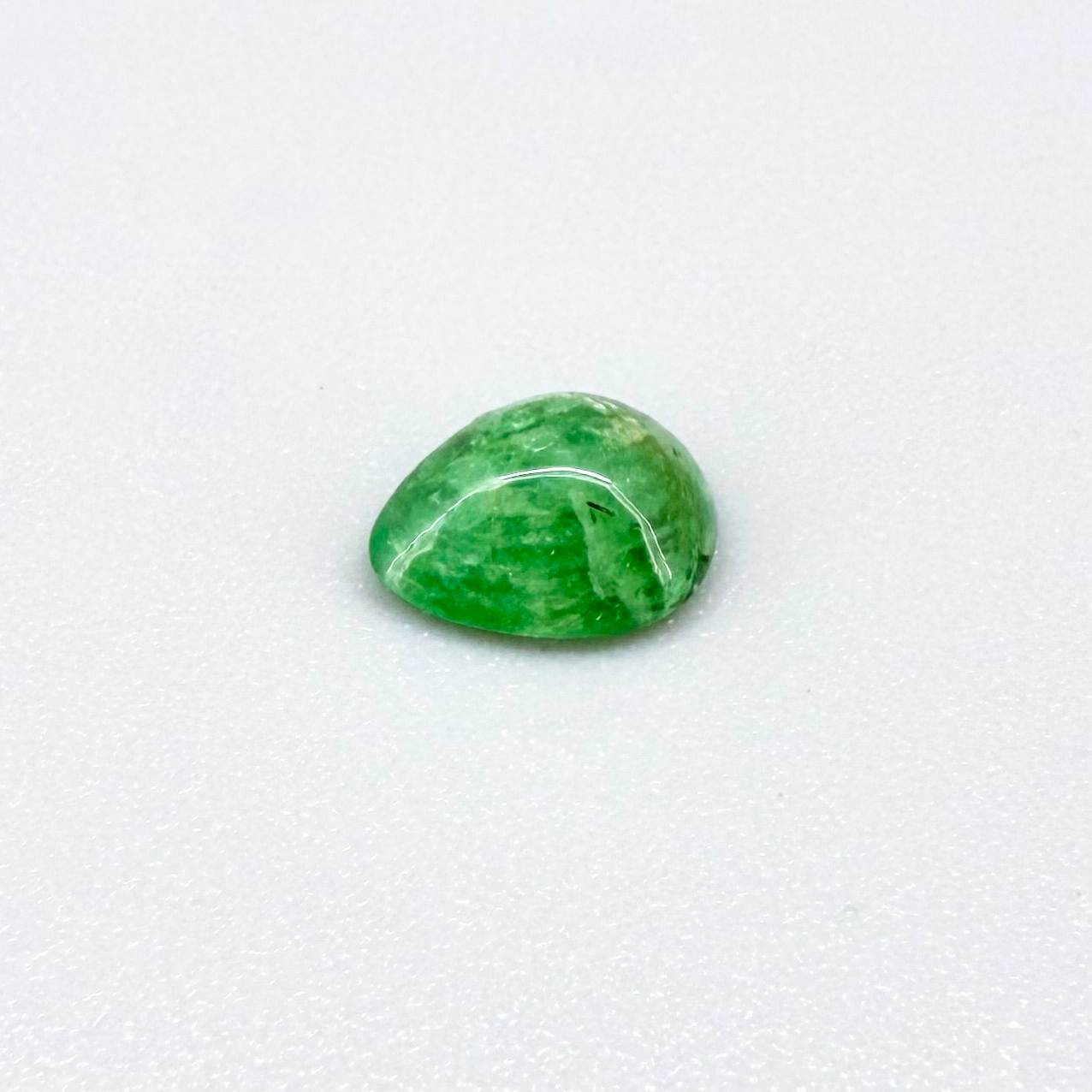0.75 ct natural untreated emerald from Zambia, one side polished and the other cabochon-shaped.