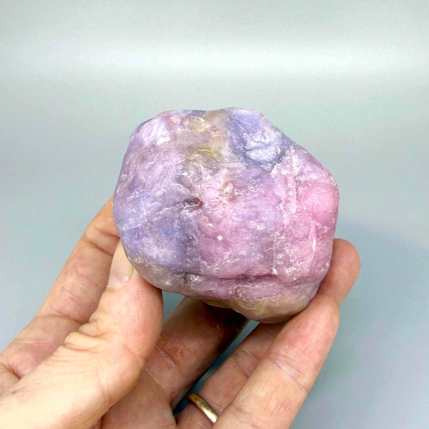 Natural ruby rough stone in lilac to purplish-pink tones, uncut corundum specimen.