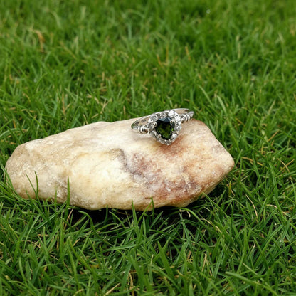White gold plated silver solitaire ring with heart-shaped green sapphire and cubic zirconia centerpiece.