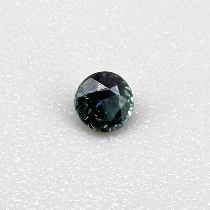 0.15 ct natural greenish-blue sapphire from Bangkaja, round cut.