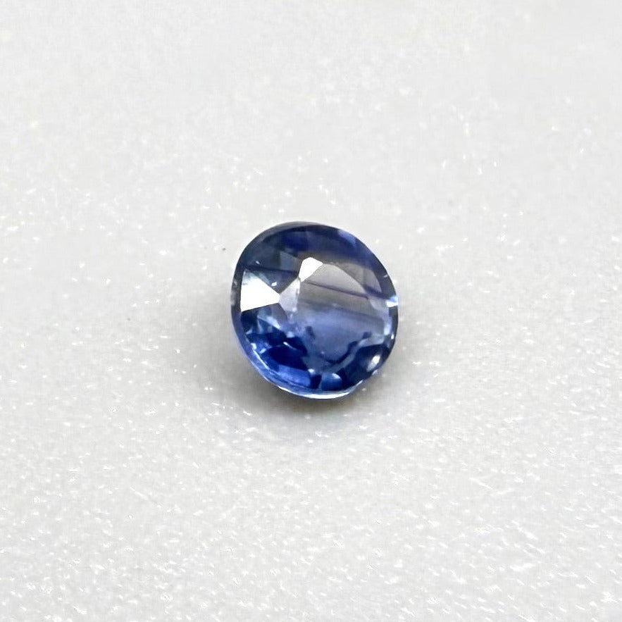 0.2 ct natural blue sapphire with visible color inclusion pattern, round cut.