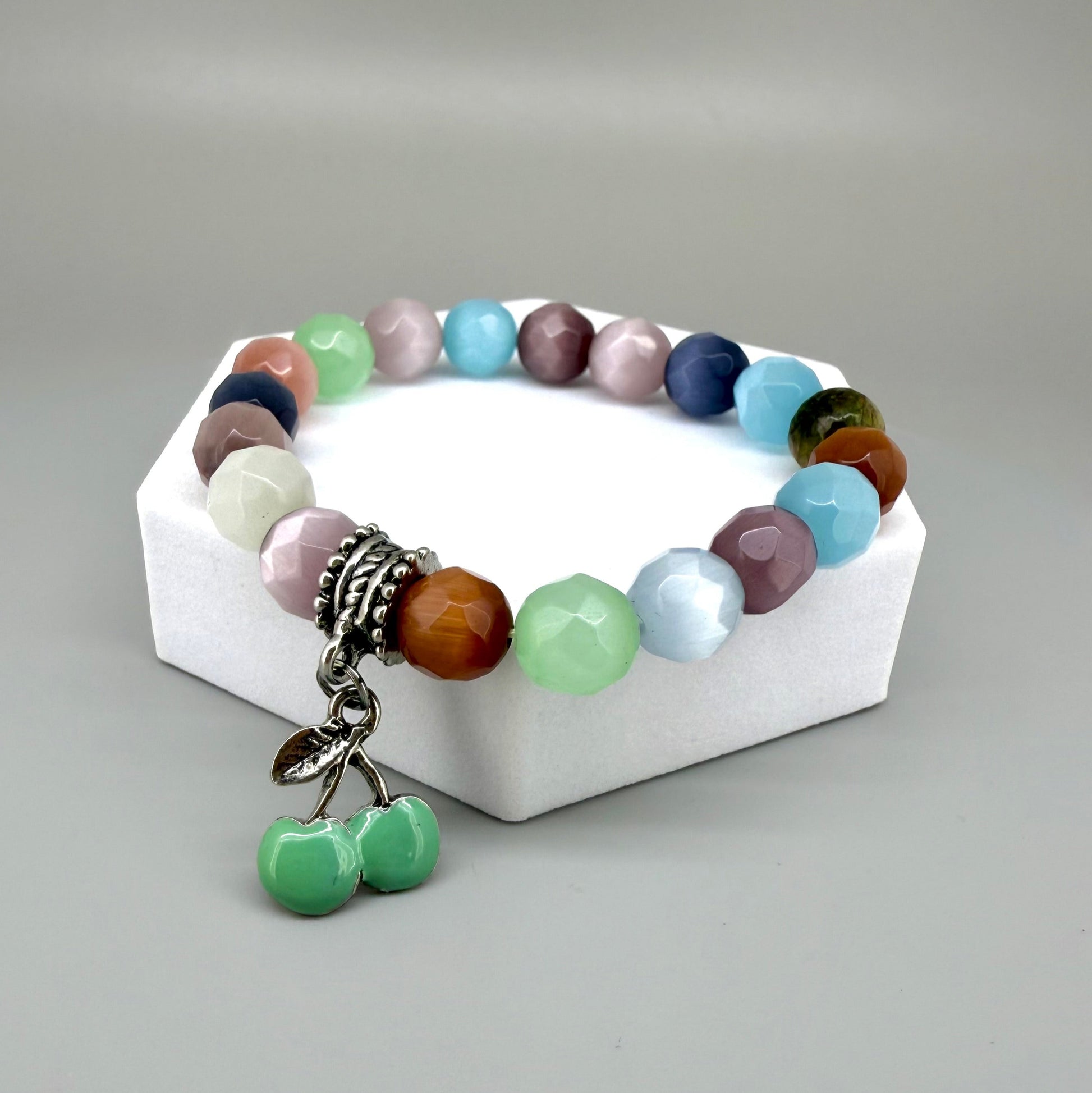 Pastel cat’s eye beaded bracelet, 19cm, multicolor shimmering beads with green cherry charm on elastic stretch band.