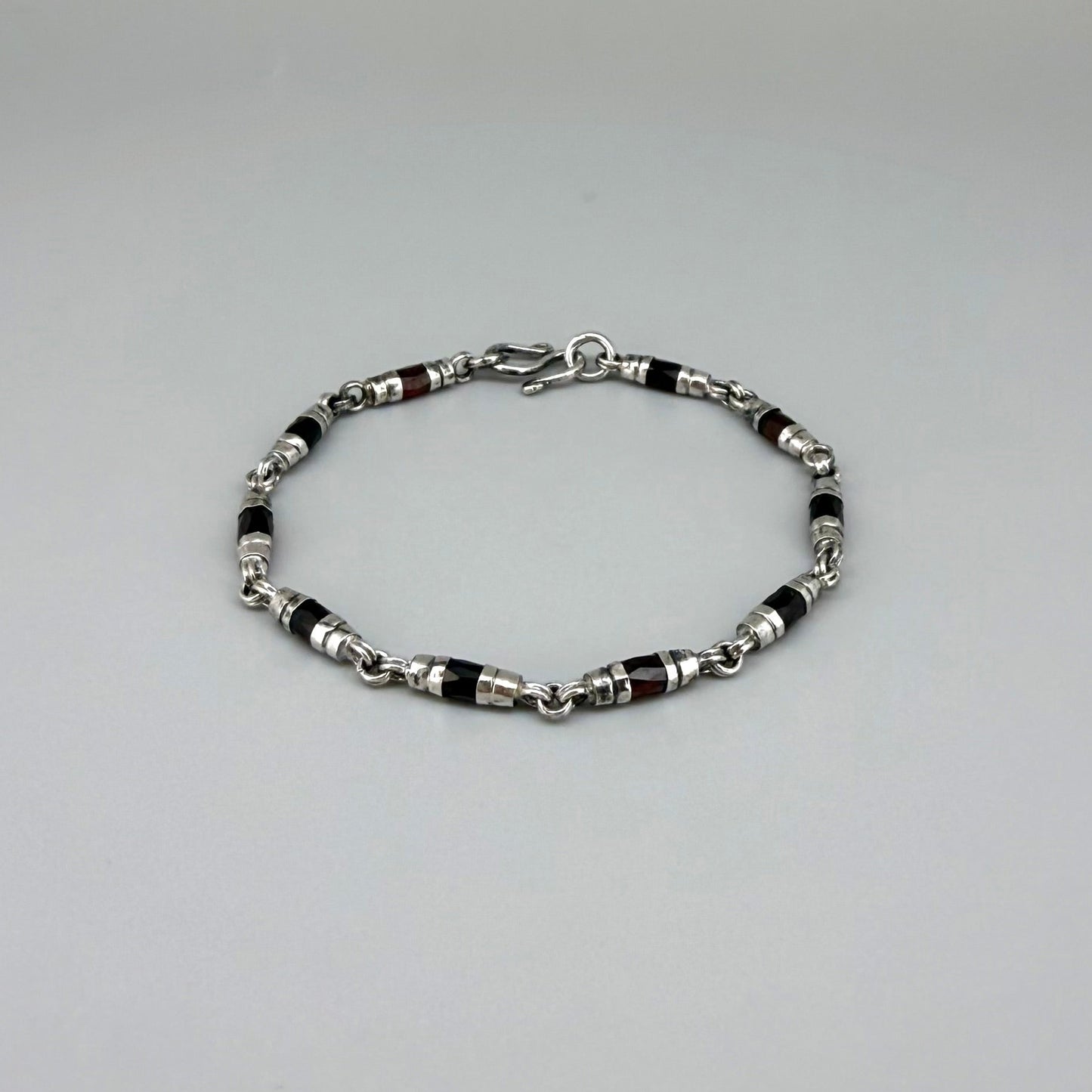 Garnet Pyrope bracelet in sterling silver with white gold plating, elegant design on neutral background
