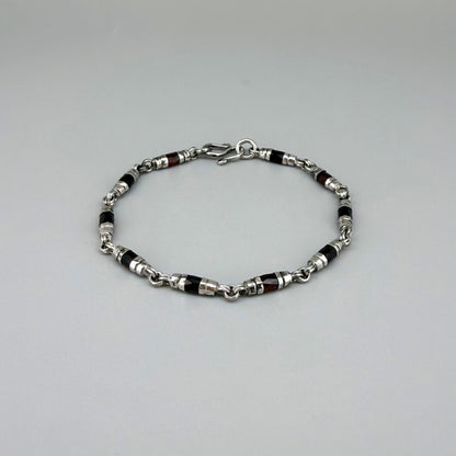 Garnet Pyrope bracelet in sterling silver with white gold plating, elegant design on neutral background