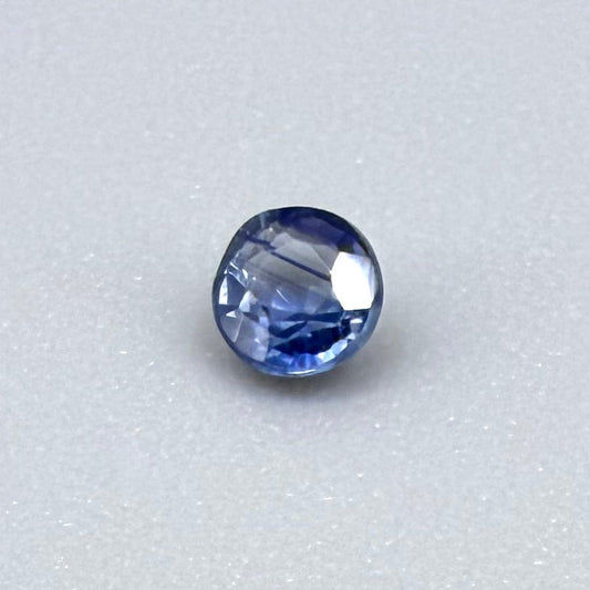0.2 ct natural blue sapphire with visible color inclusion pattern, round cut.