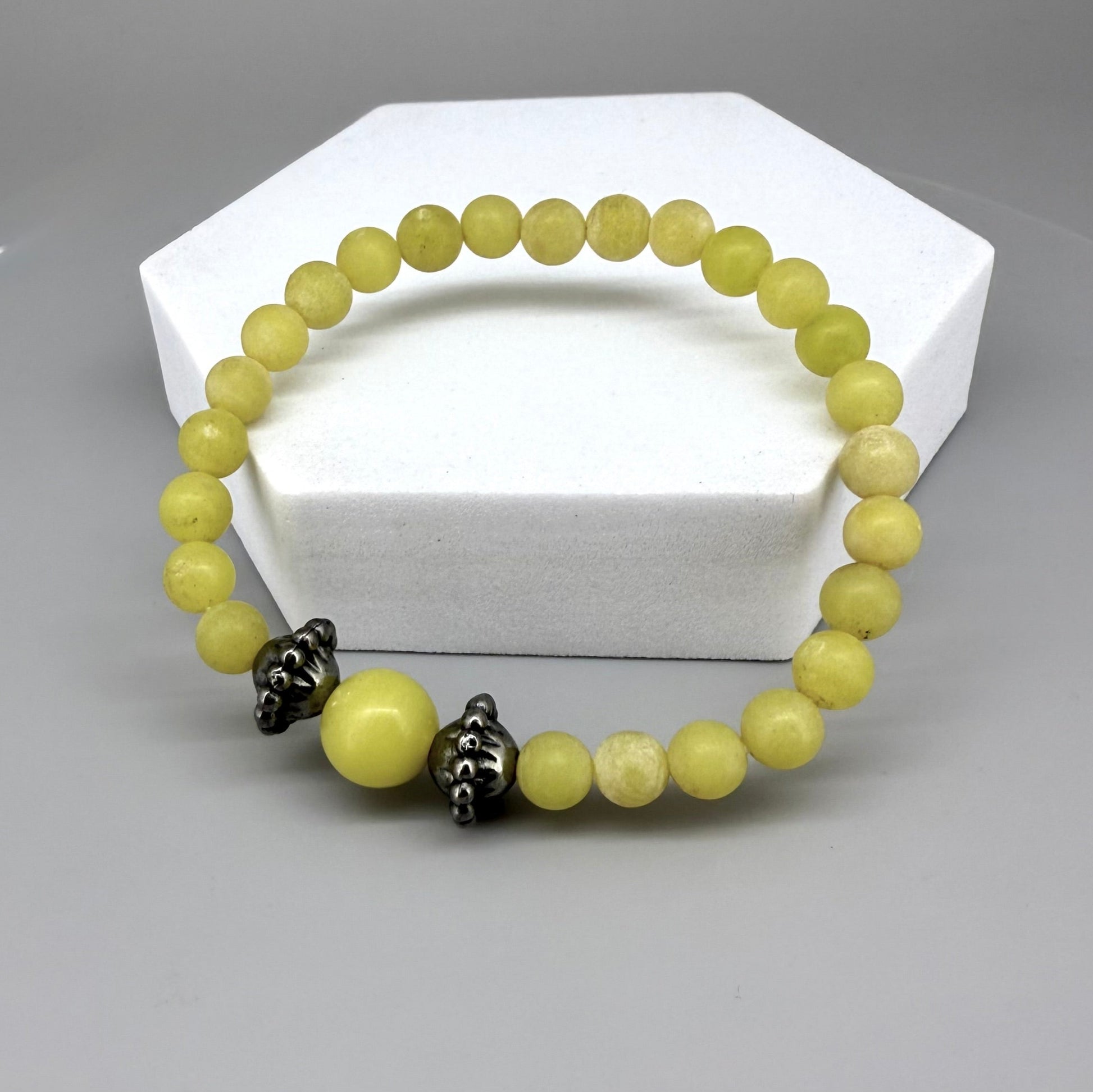 Yellow jasper beaded bracelet, 18cm, vibrant gemstone beads with larger focal bead framed by carved metal accents on elastic stretch band.