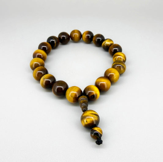 Tiger’s Eye mala bracelet with golden-brown chatoyant gemstone beads worn on wrist.