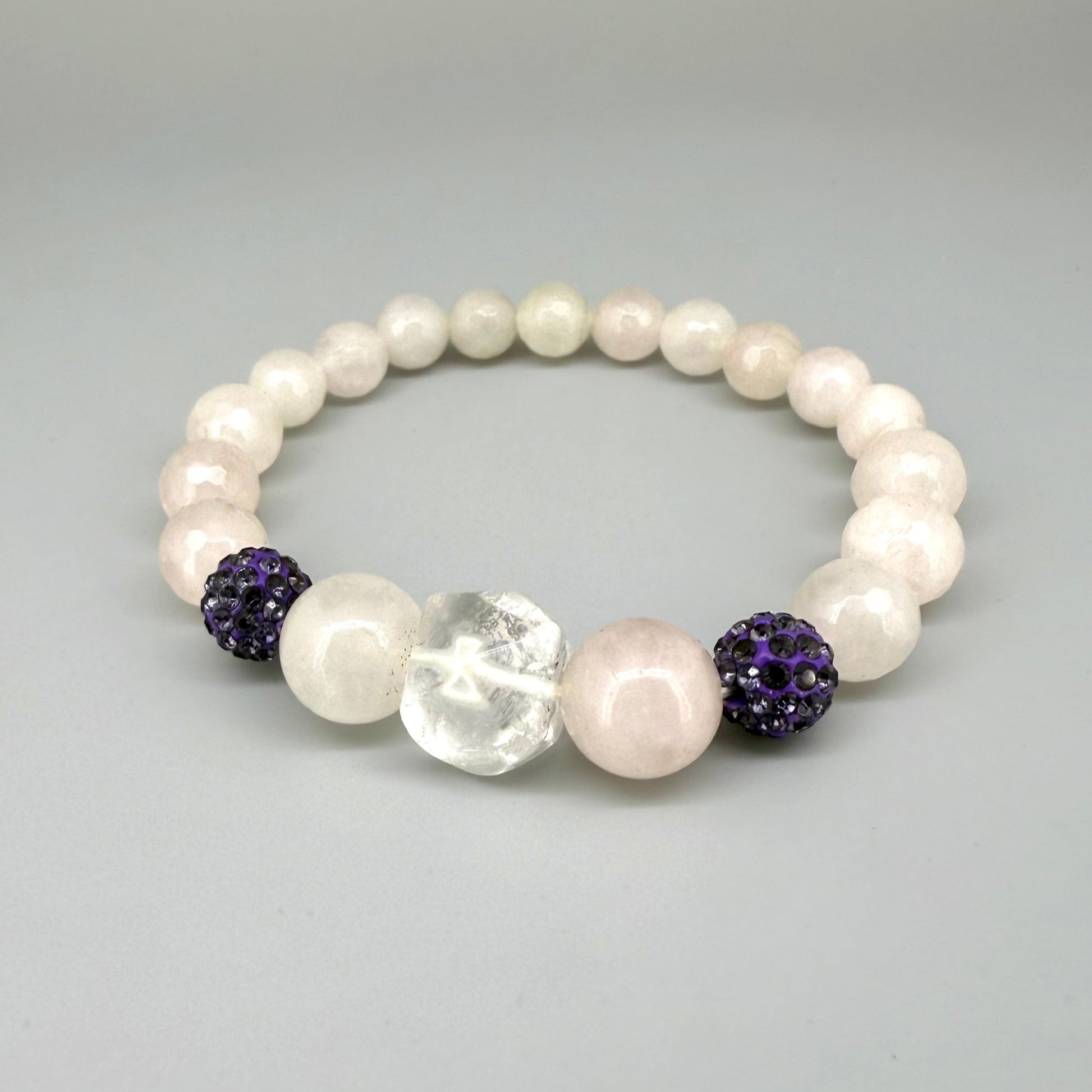 Rose quartz beaded bracelet, 19cm, light pink gemstone beads with larger central rose quartz bead and black sparkling accent beads on elastic stretch band.