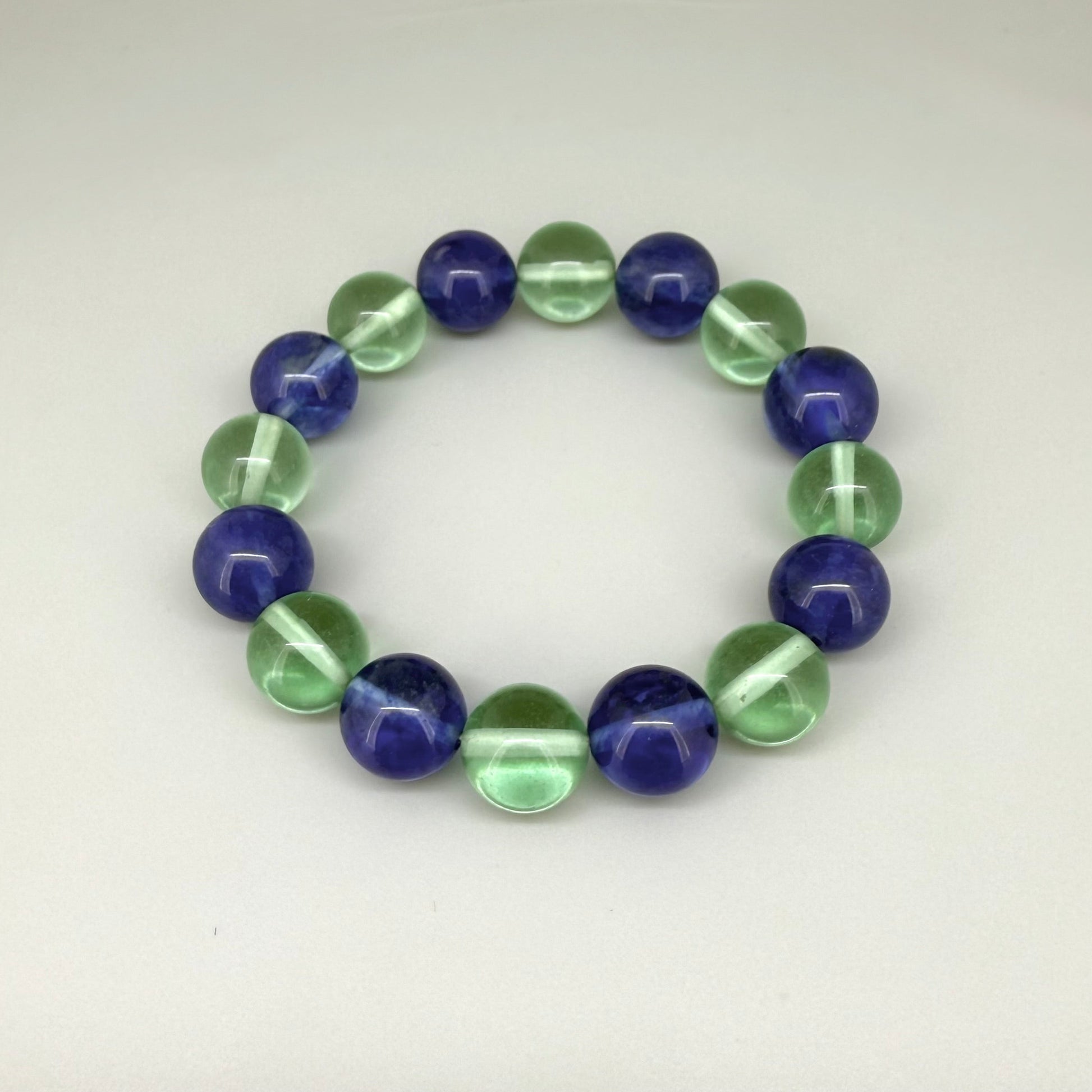 Quartz beaded bracelet, 18cm, alternating dark blue and light green dyed gemstone beads on elastic stretch band.
