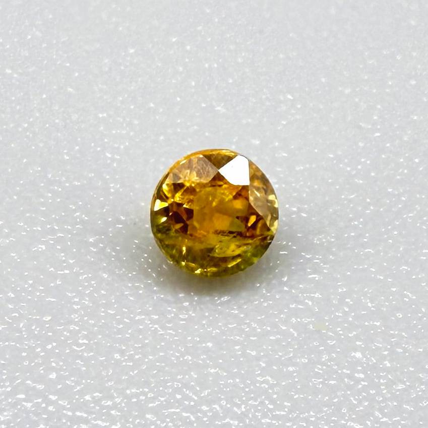 0.2 ct natural orange sapphire from Bangkaja, round cut.