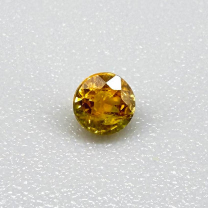 0.2 ct natural orange sapphire from Bangkaja, round cut.