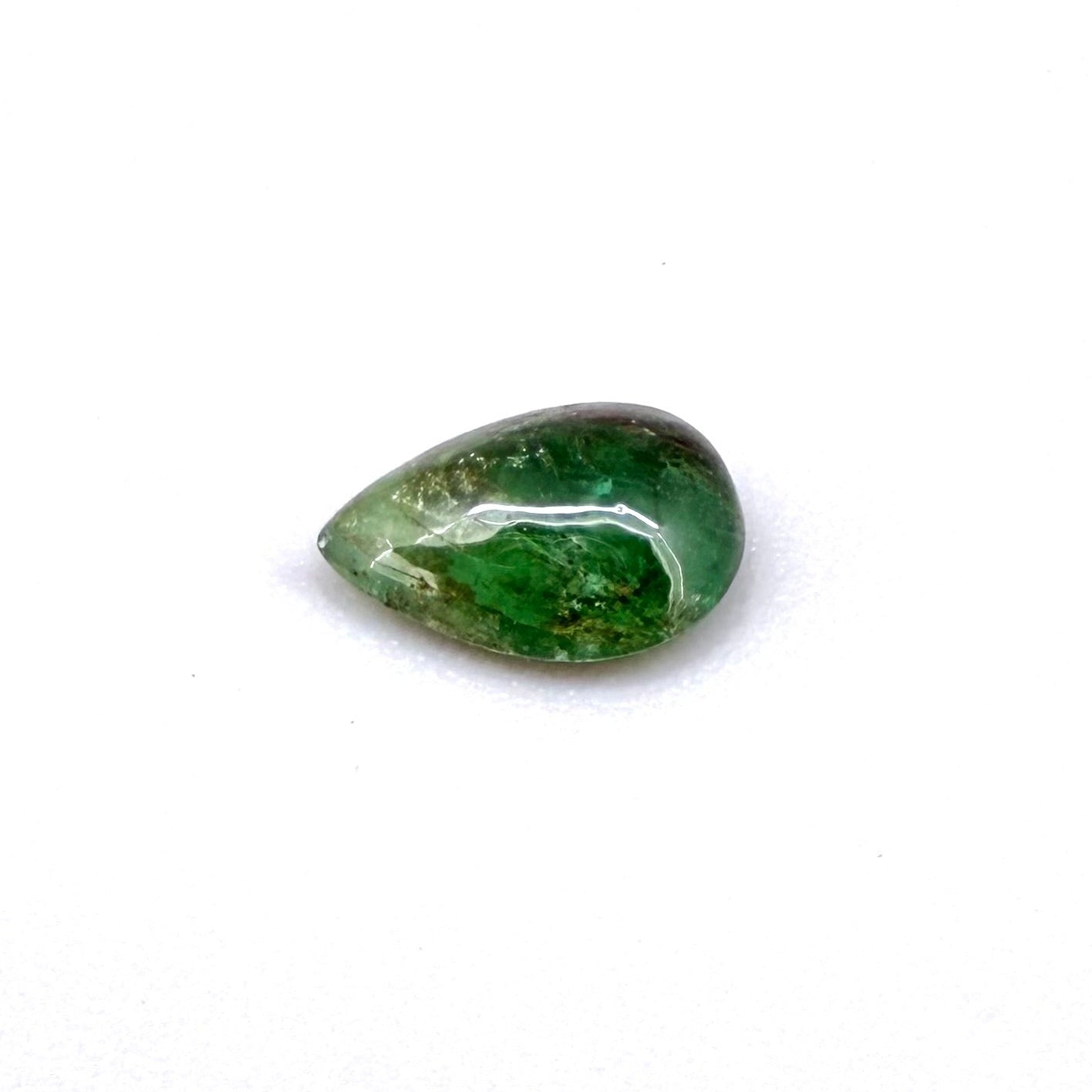 0.82 ct natural untreated emerald from Zambia, one side polished and the other cabochon-shaped.