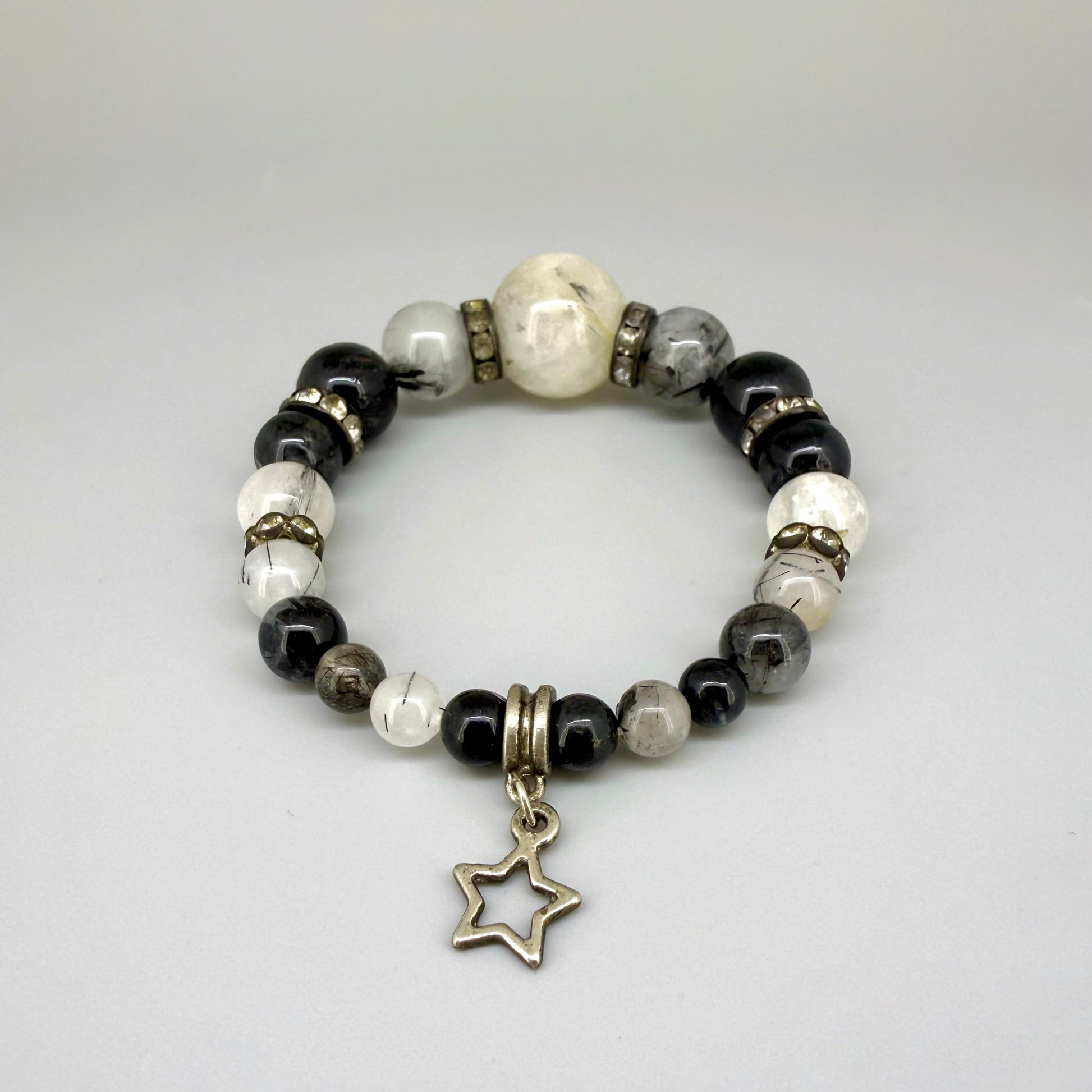Rutilated quartz beaded bracelet, 18cm, black rutile inclusions with larger light bead and star charm on elastic stretch band.