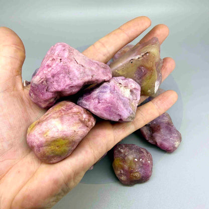 Natural ruby rough lot weighing approximately 1,380 g, featuring pink to lilac-pink corundum stones in raw form.