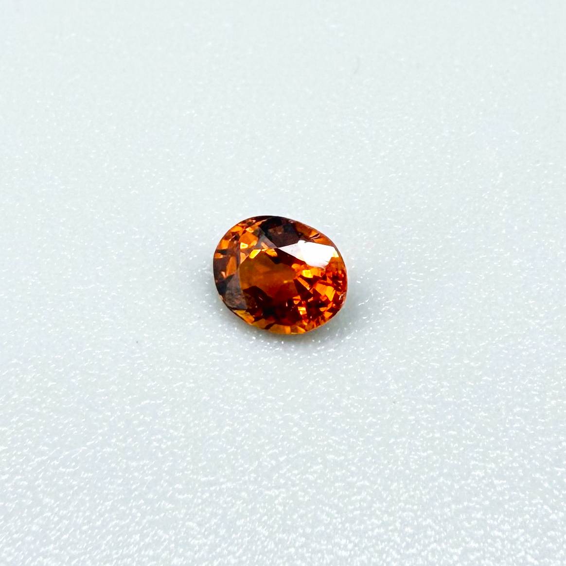 0.56 ct natural spessartine garnet from Namibia, fiery orange, faceted.