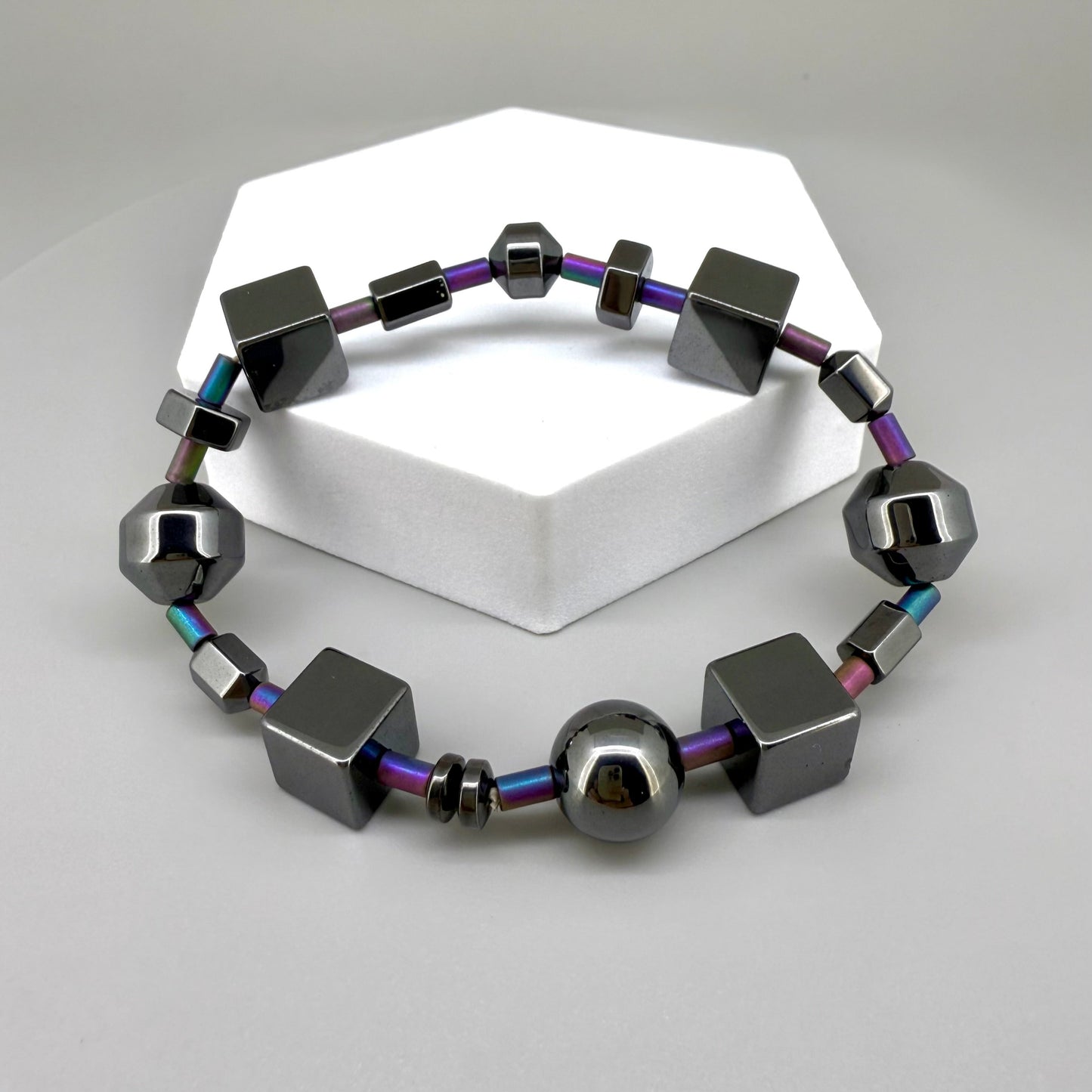 Hematite bracelet, 20cm, geometric cube and sphere beads with rainbow-toned connectors on elastic stretch band.