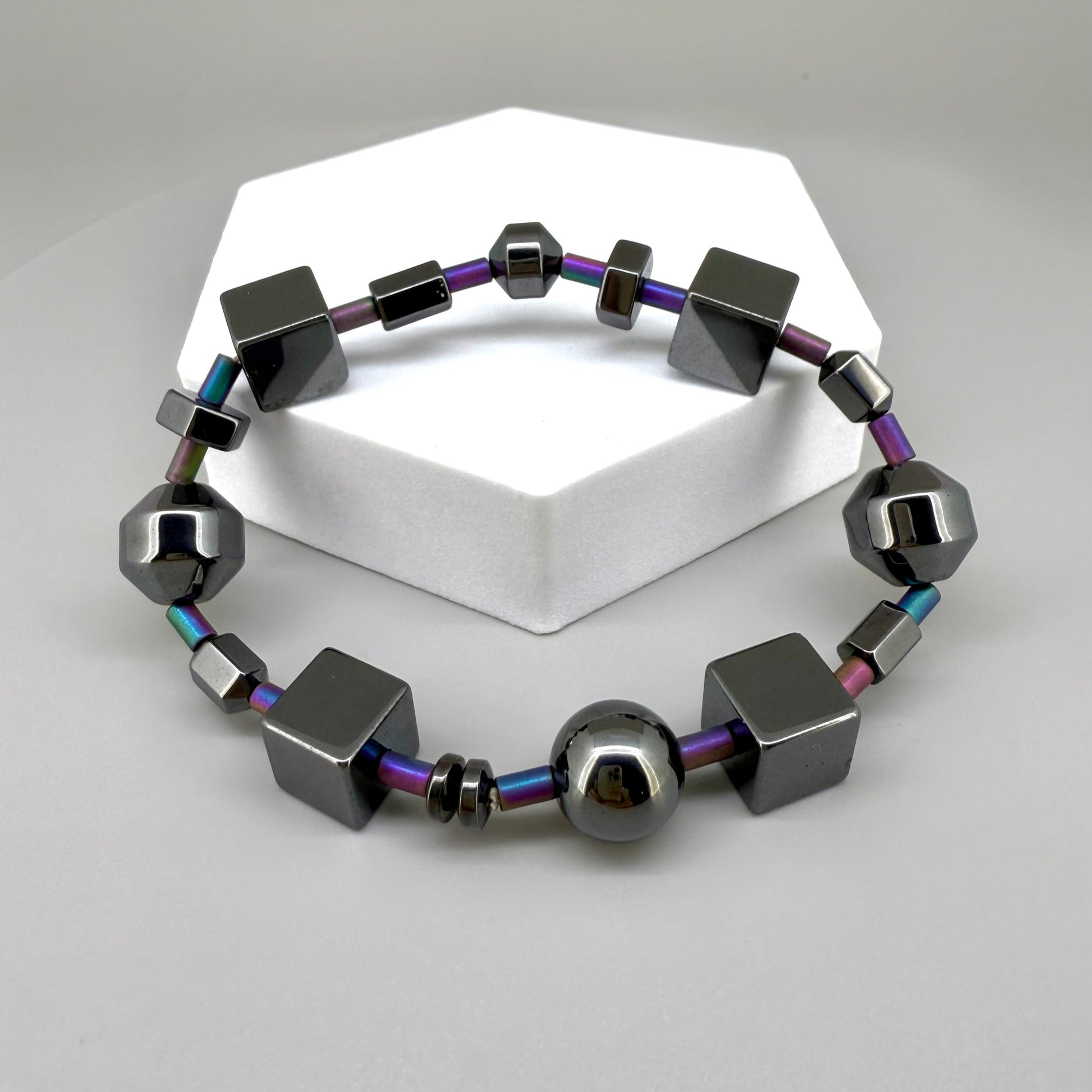 Hematite bracelet, 20cm, geometric cube and sphere beads with rainbow-toned connectors on elastic stretch band.