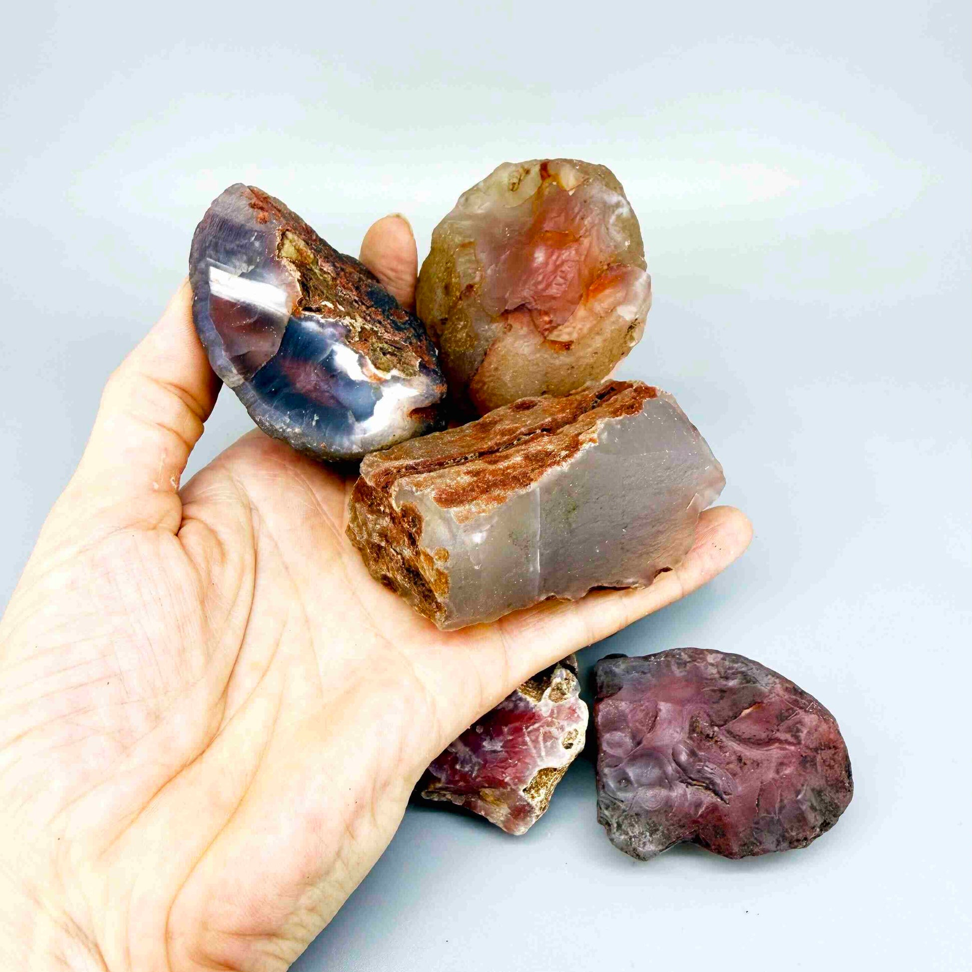 Mixed chalcedony rough stones with pink, orange-red and grey banded patterns, natural quartz lot.