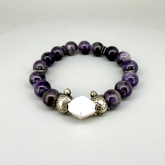 Amethyst beaded bracelet, 18cm, violet gemstone beads with pink-white accent stone and two metal turtle beads on elastic stretch band.
