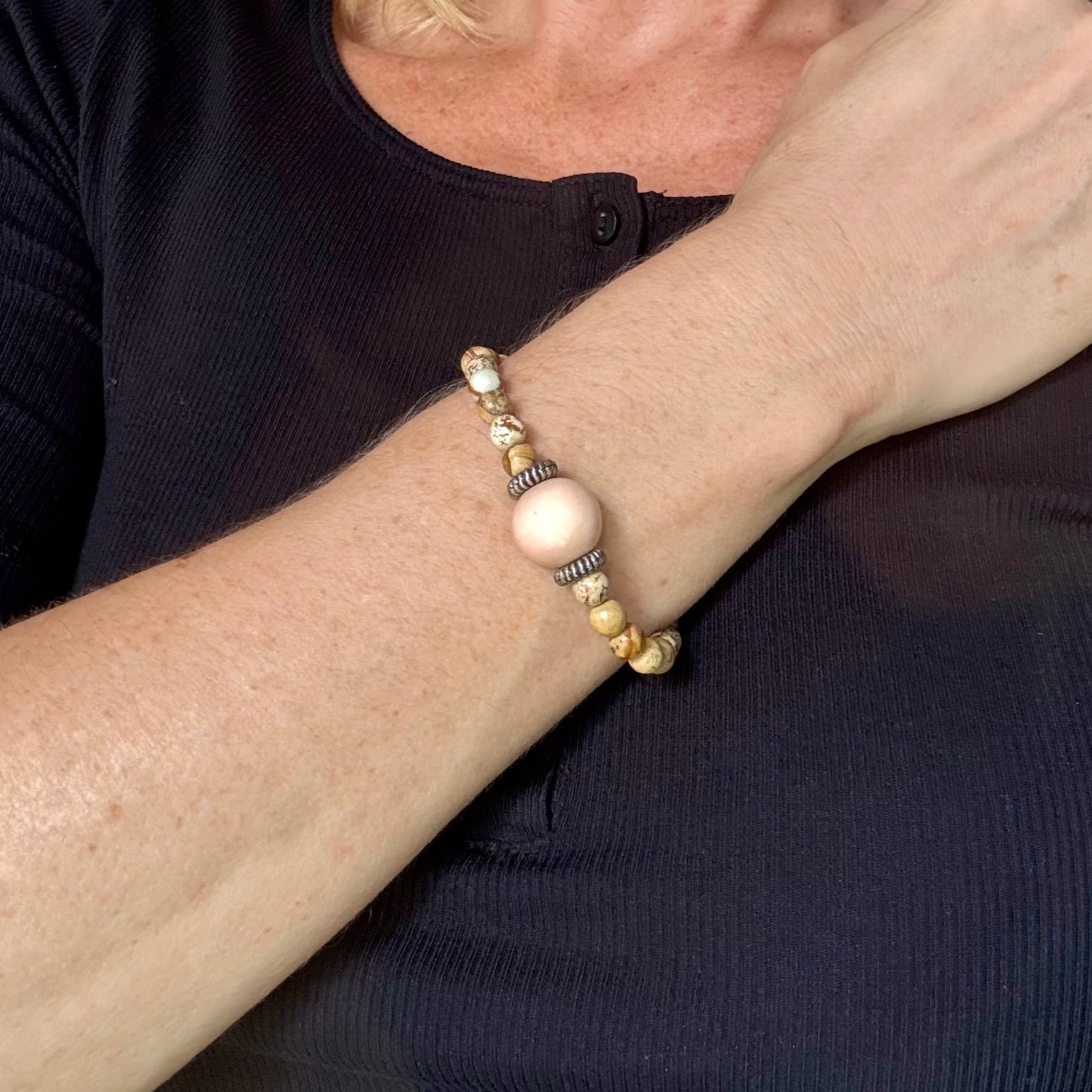 Jasper beaded bracelet, 18cm, light earthy tones with peach-colored focal bead on elastic stretch band.