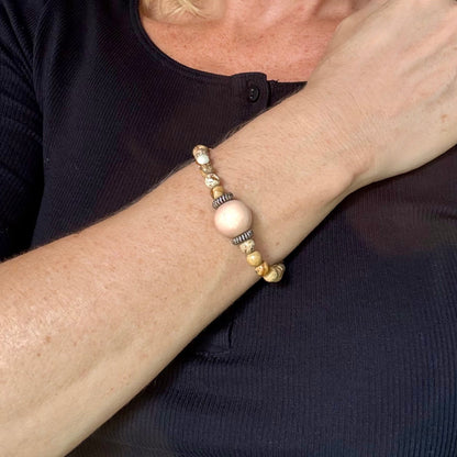 Jasper beaded bracelet, 18cm, light earthy tones with peach-colored focal bead on elastic stretch band.