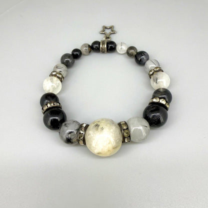 Rutilated quartz beaded bracelet, 18cm, black rutile inclusions with larger light bead and star charm on elastic stretch band.