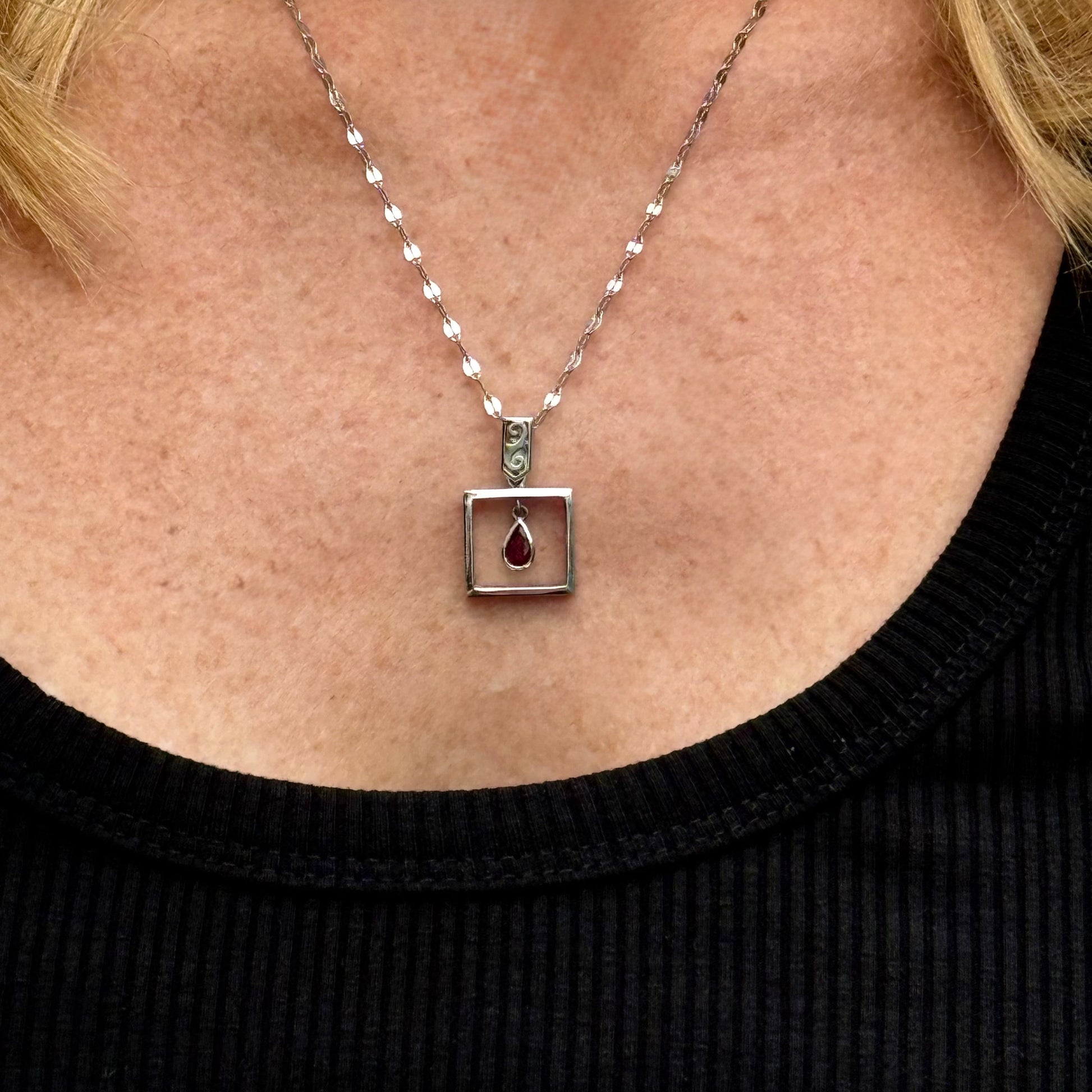 Handcrafted modern silver pendant with free-hanging teardrop ruby (0.55 ct) inside a square frame.