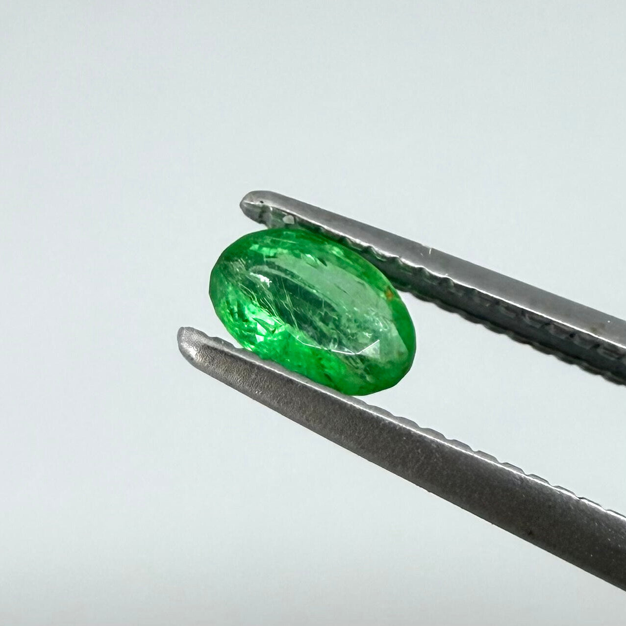 0.22 ct natural untreated Zambian emerald, oval faceted with vivid bluish-green color.