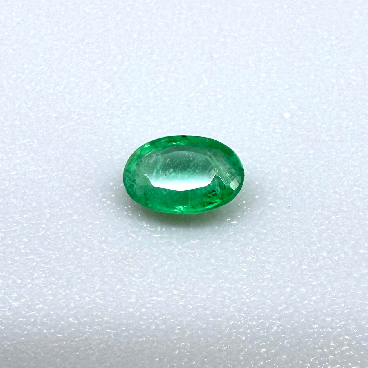 0.16 ct natural untreated Zambian emerald, oval faceted with vivid bluish-green color.