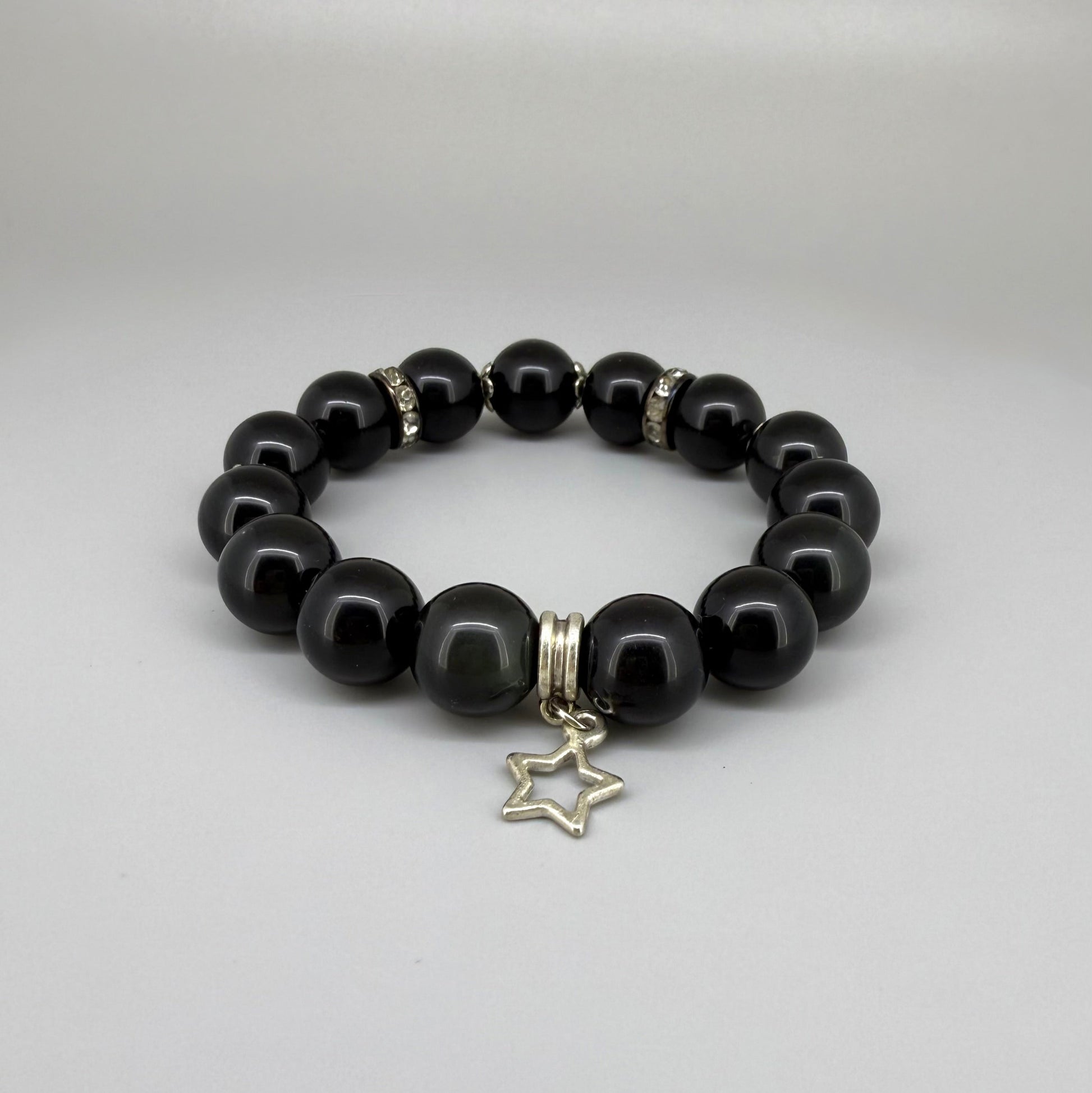 Obsidian beaded bracelet, 18cm, natural black gemstone beads with silver-toned star charm on elastic stretch band.