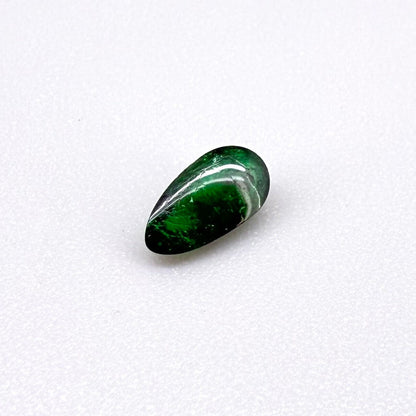0.67 ct natural untreated emerald from Zambia, one side polished and the other cabochon-shaped.
