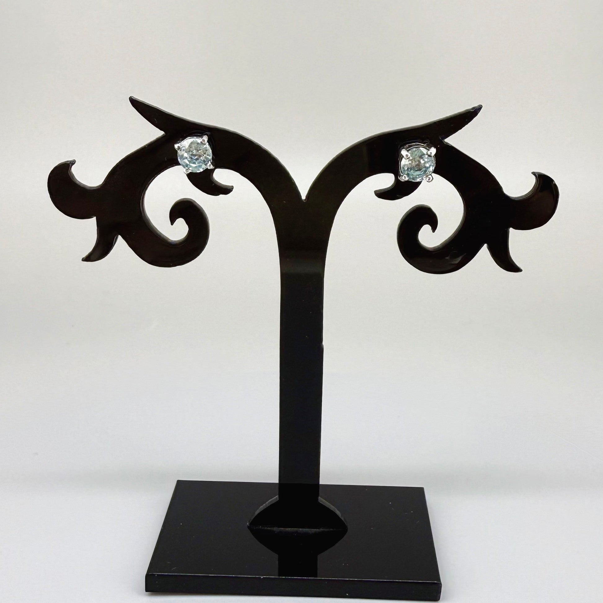 White gold plated sterling silver stud earrings featuring natural blue zircons with high brilliance and clarity.
