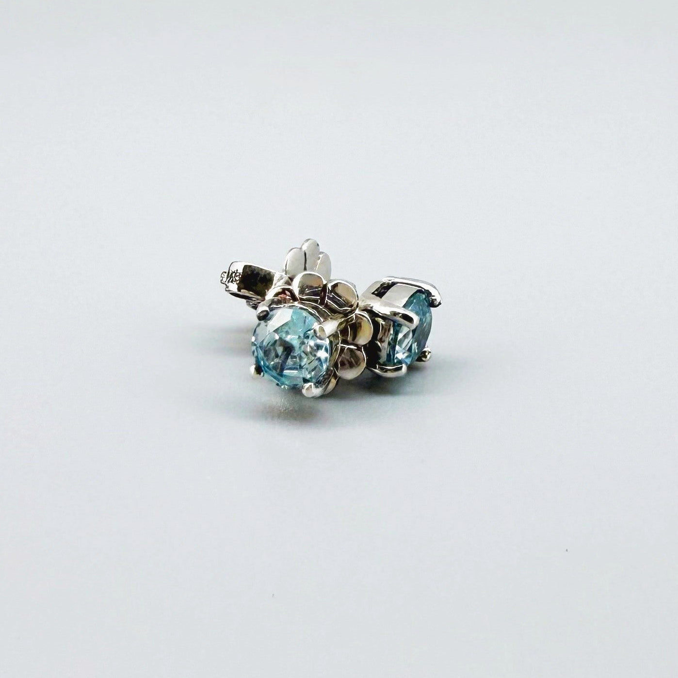 White gold plated sterling silver stud earrings featuring natural blue zircons with high brilliance and clarity.
