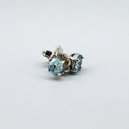 White gold plated sterling silver stud earrings featuring natural blue zircons with high brilliance and clarity.