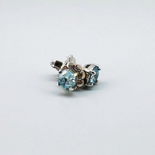 White gold plated sterling silver stud earrings featuring natural blue zircons with high brilliance and clarity.