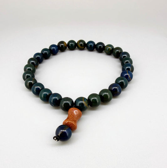 Sapphire mala bracelet made from natural sapphire beads, photographed on neutral background.