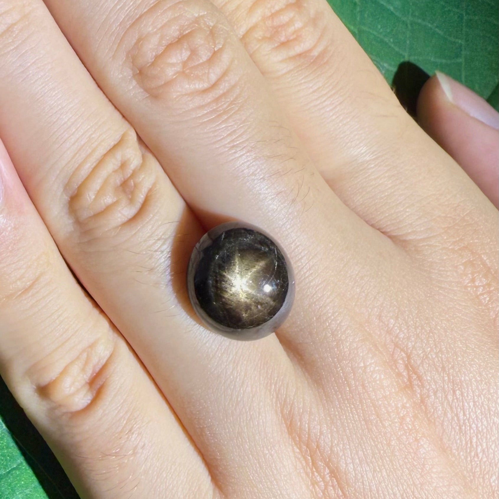 Golden-brown star sapphire cabochon, natural gemstone with visible asterism