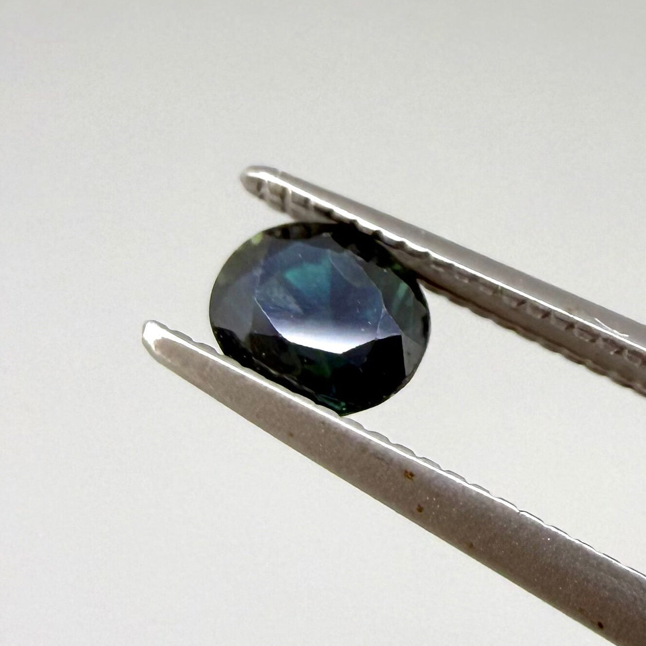 0.67 ct natural blue-green sapphire from Bangkaja, faceted cut.