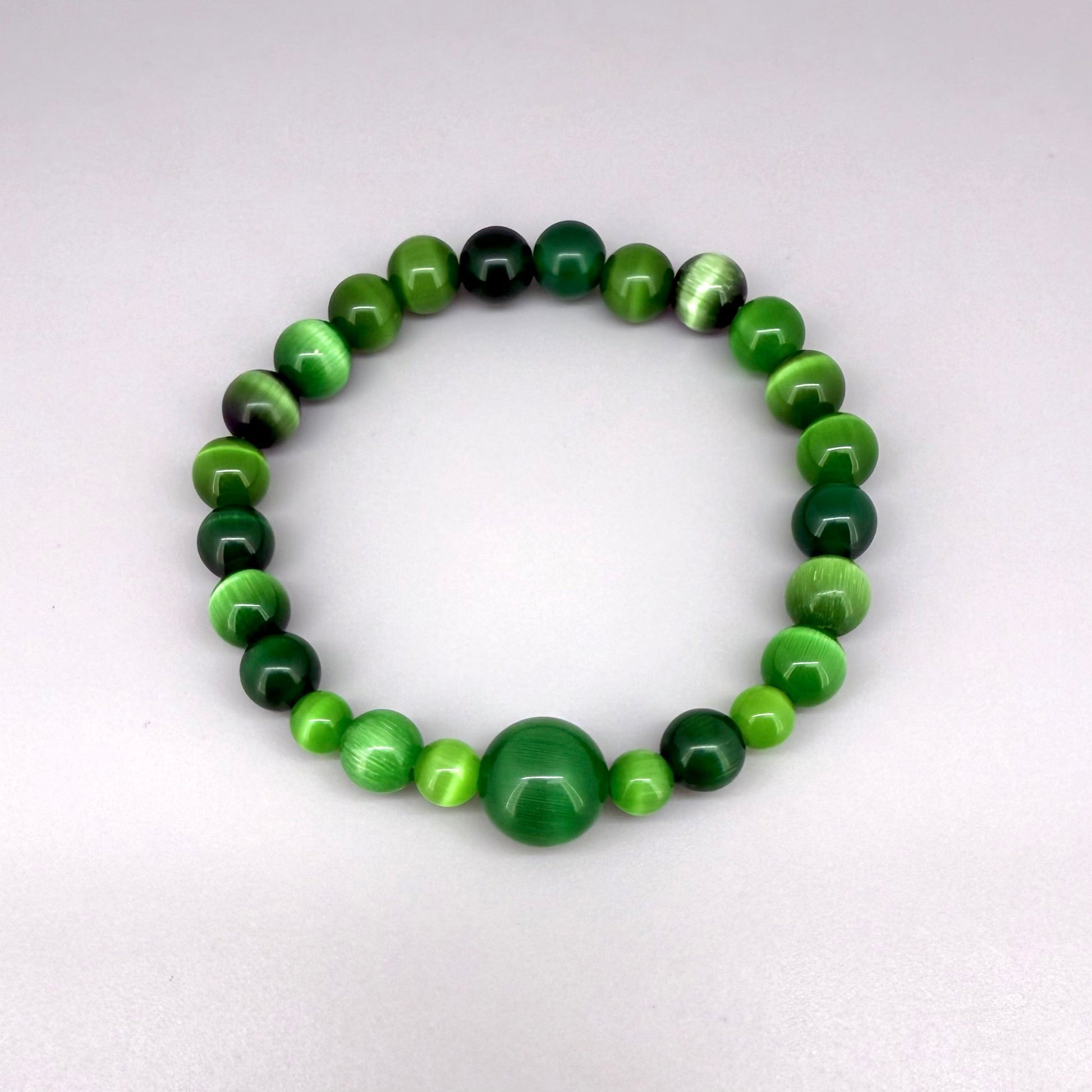 Green cat’s eye beaded bracelet, 18cm, shimmering green gemstone beads with one larger focal bead on elastic stretch band.