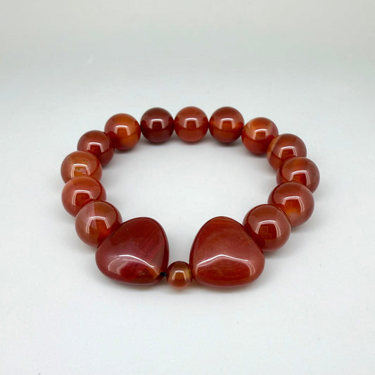 Carnelian beaded bracelet, 19cm, natural orange-red gemstone beads with two larger heart-shaped carnelian stones on elastic stretch band.