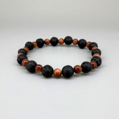 Lava and goldstone beaded bracelet, 18cm, alternating matte black lava beads and smaller shimmering golden-brown man-made goldstone beads on elastic stretch band.