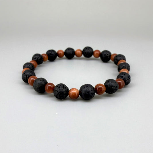 Lava and goldstone beaded bracelet, 18cm, alternating matte black lava beads and smaller shimmering golden-brown man-made goldstone beads on elastic stretch band.