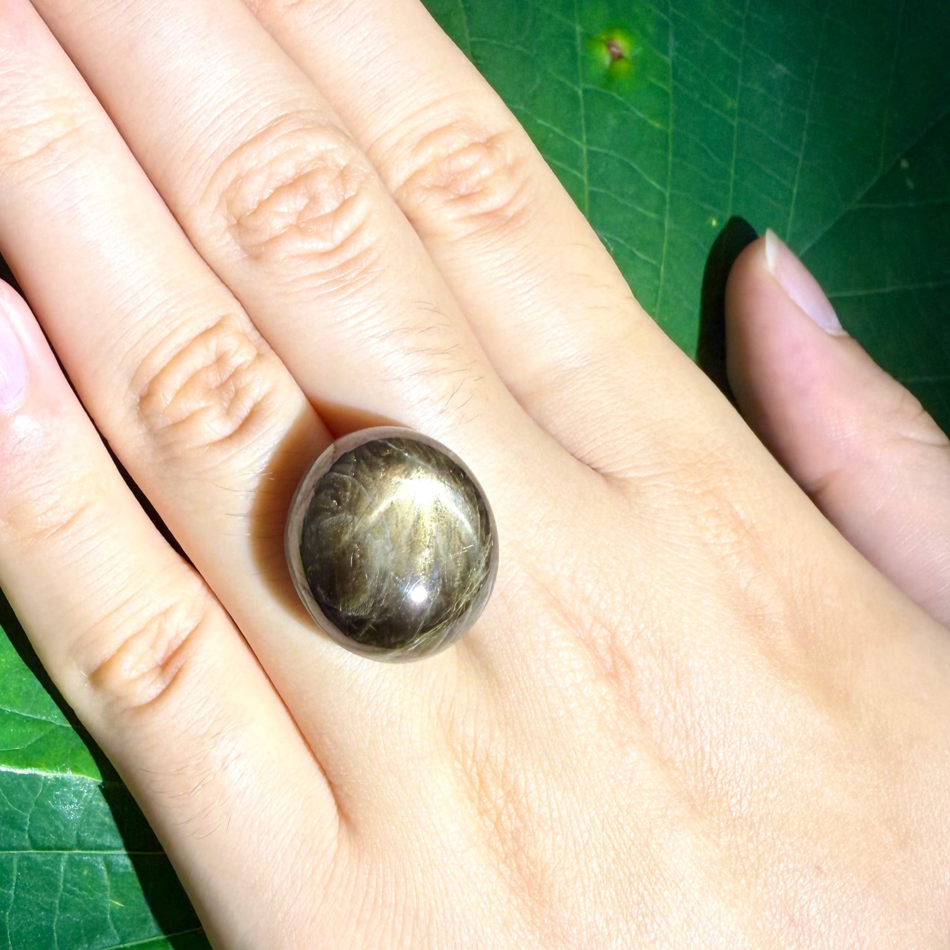 Golden-brown star sapphire cabochon, natural gemstone with visible asterism