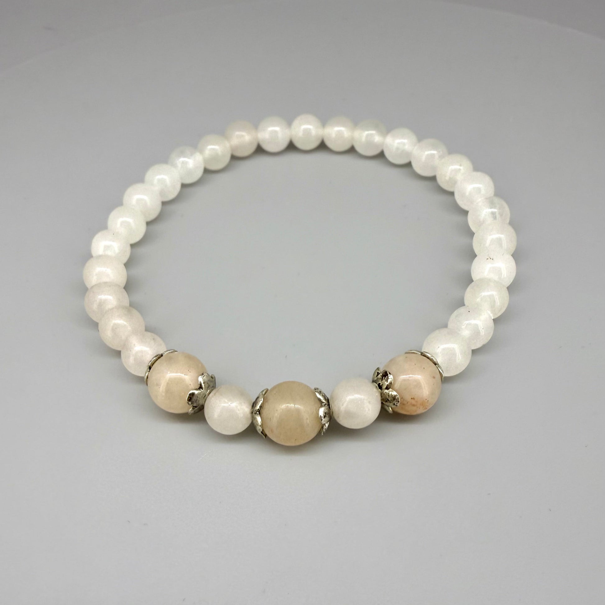 Jade beaded bracelet, 19cm, natural green gemstone beads with three slightly larger darker accent stones on elastic stretch band.
