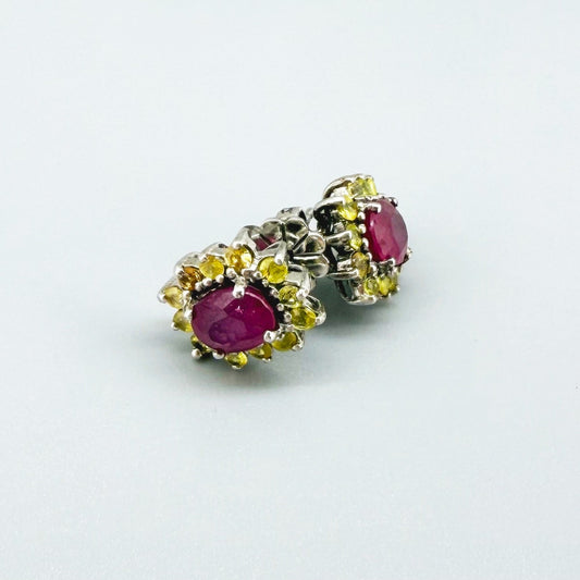Ruby and yellow sapphire stud earrings in white gold plated sterling silver with butterfly backs.