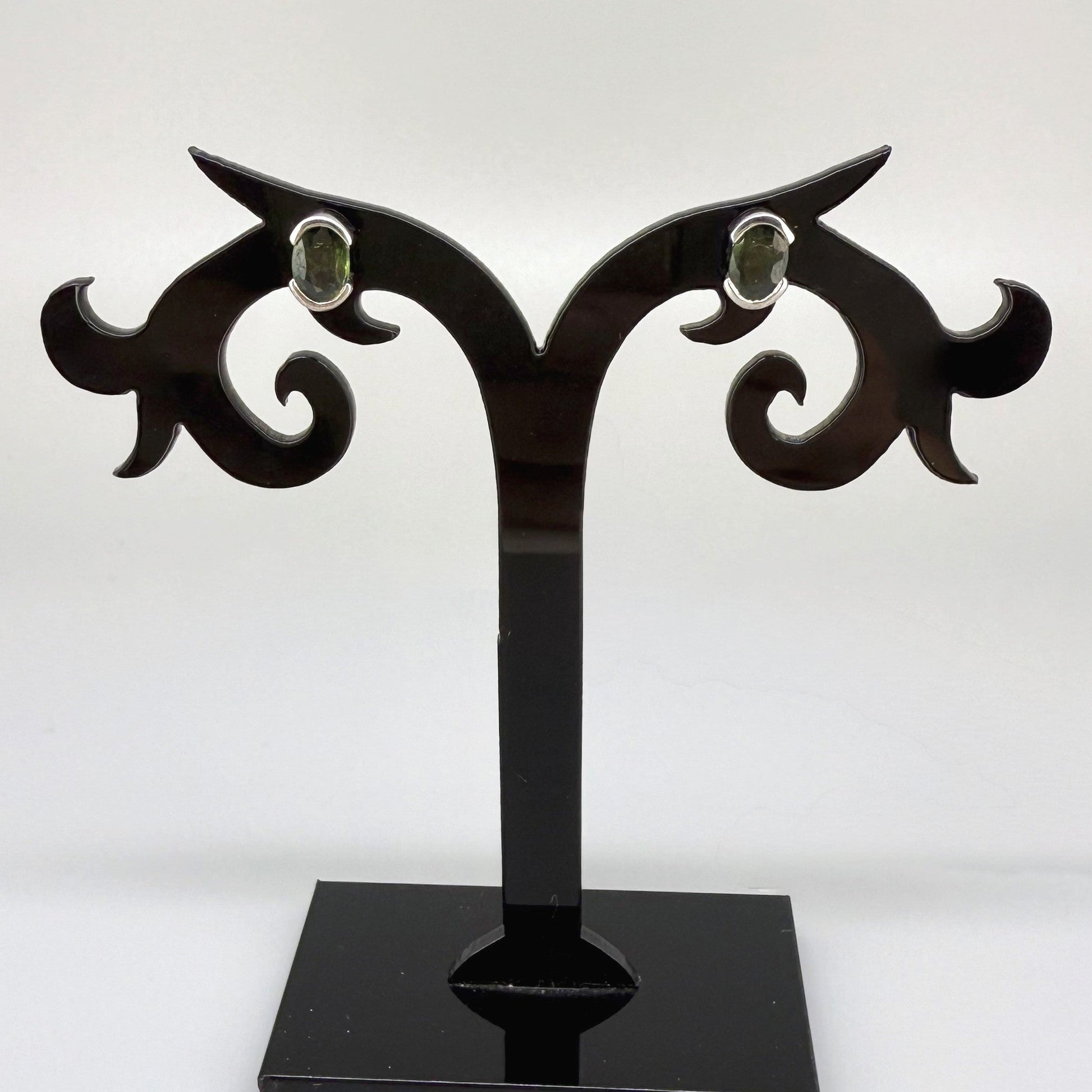 Green sapphire stud earrings in white gold plated sterling silver with butterfly backs.