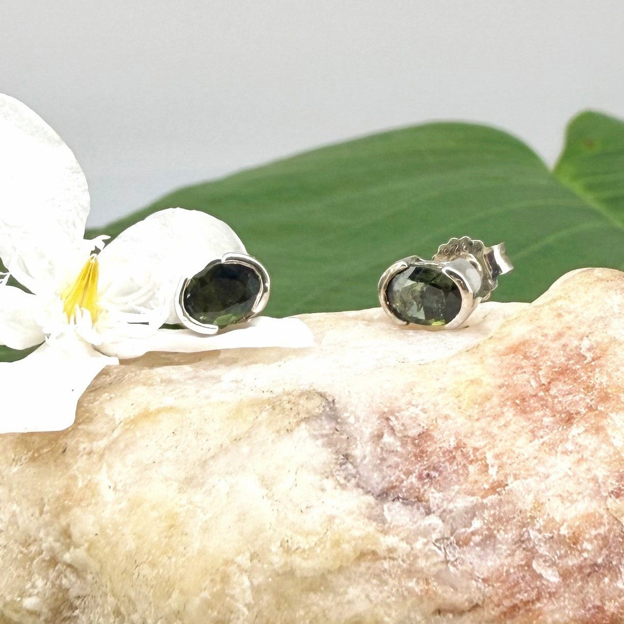 Green sapphire stud earrings in white gold plated sterling silver with butterfly backs.