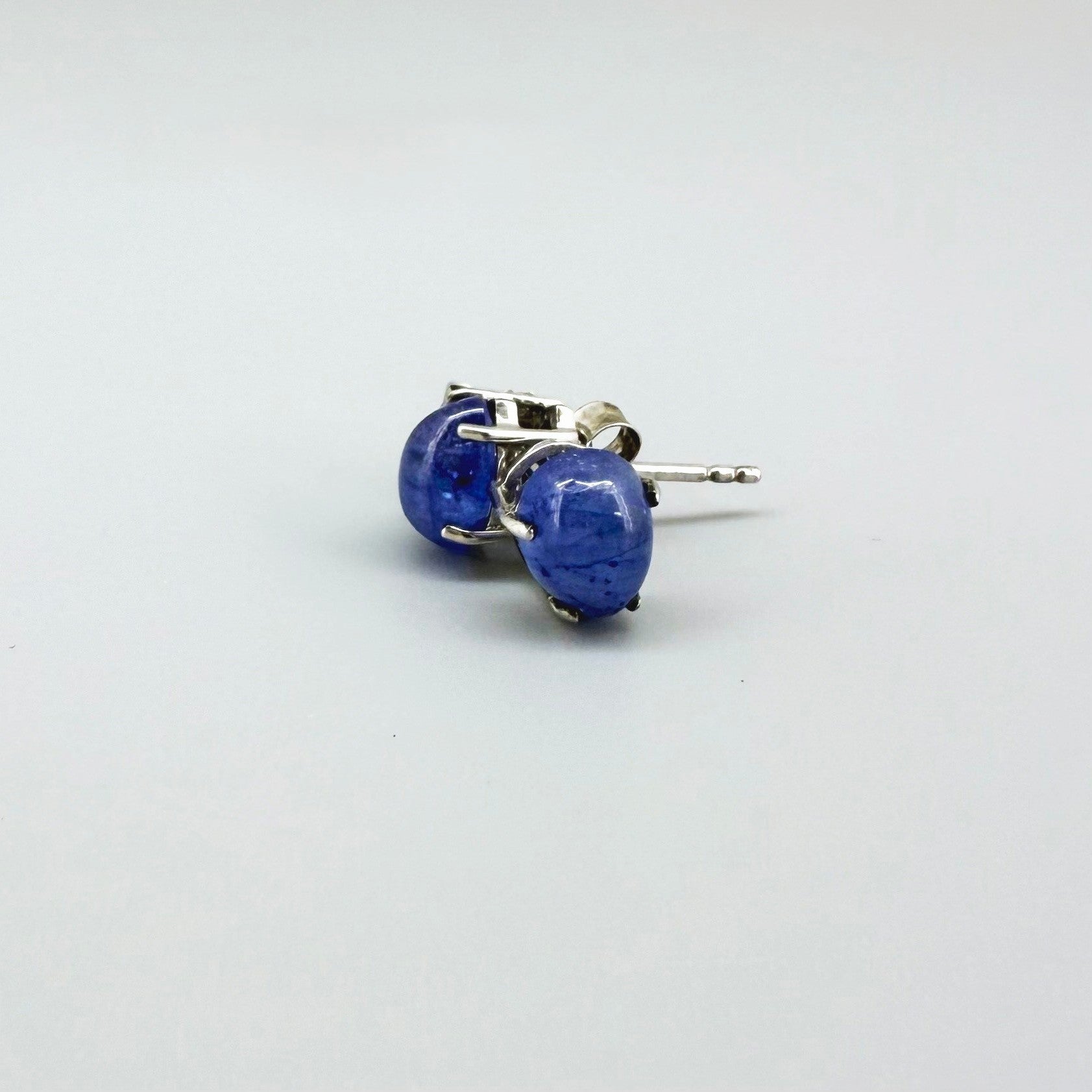 Sterling silver stud earrings with deep blue natural sapphires, plated in white gold for refined brilliance.