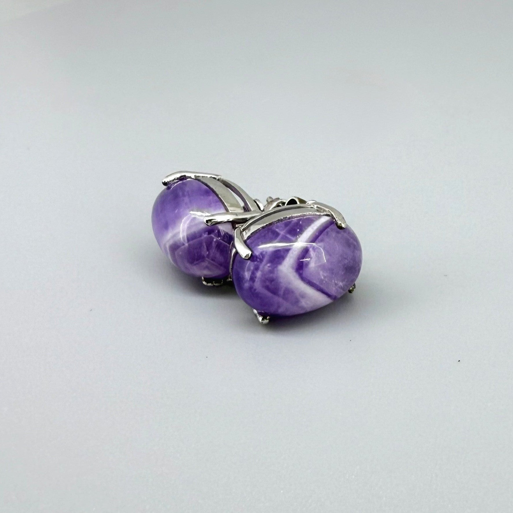 Natural amethyst stud earrings in white gold plated sterling silver with butterfly backs.
